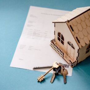 Contract, keys to the house, and a model of the house on the table.