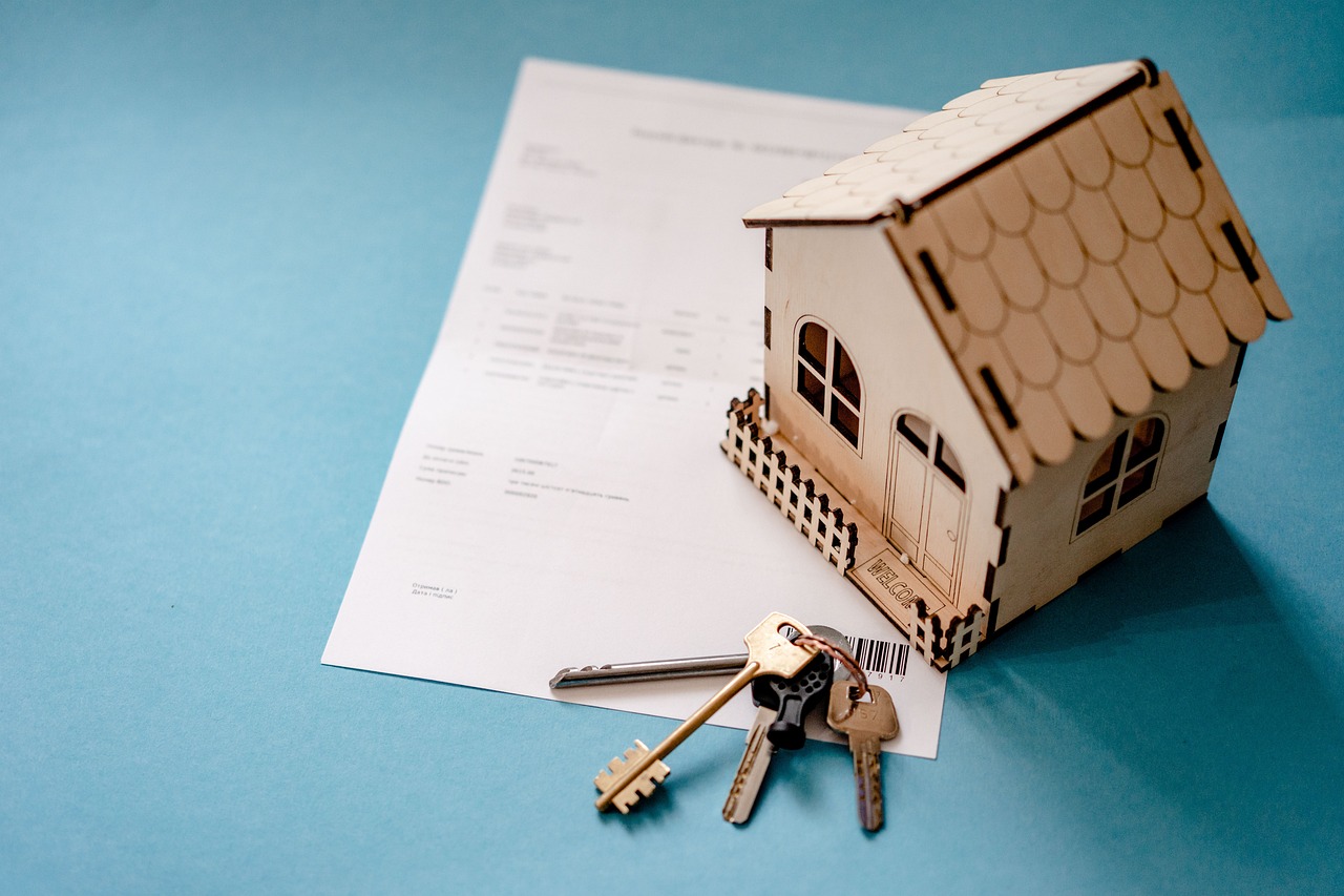 Contract, keys to the house, and a model of the house on the table.