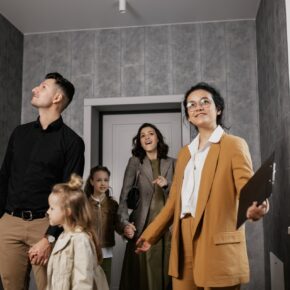 A woman in a mustard-colored suit showing potential buyers a home.